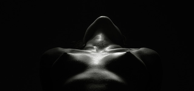 Žena v tme s nahým poprsím a zaklonenou hlavou.jpg